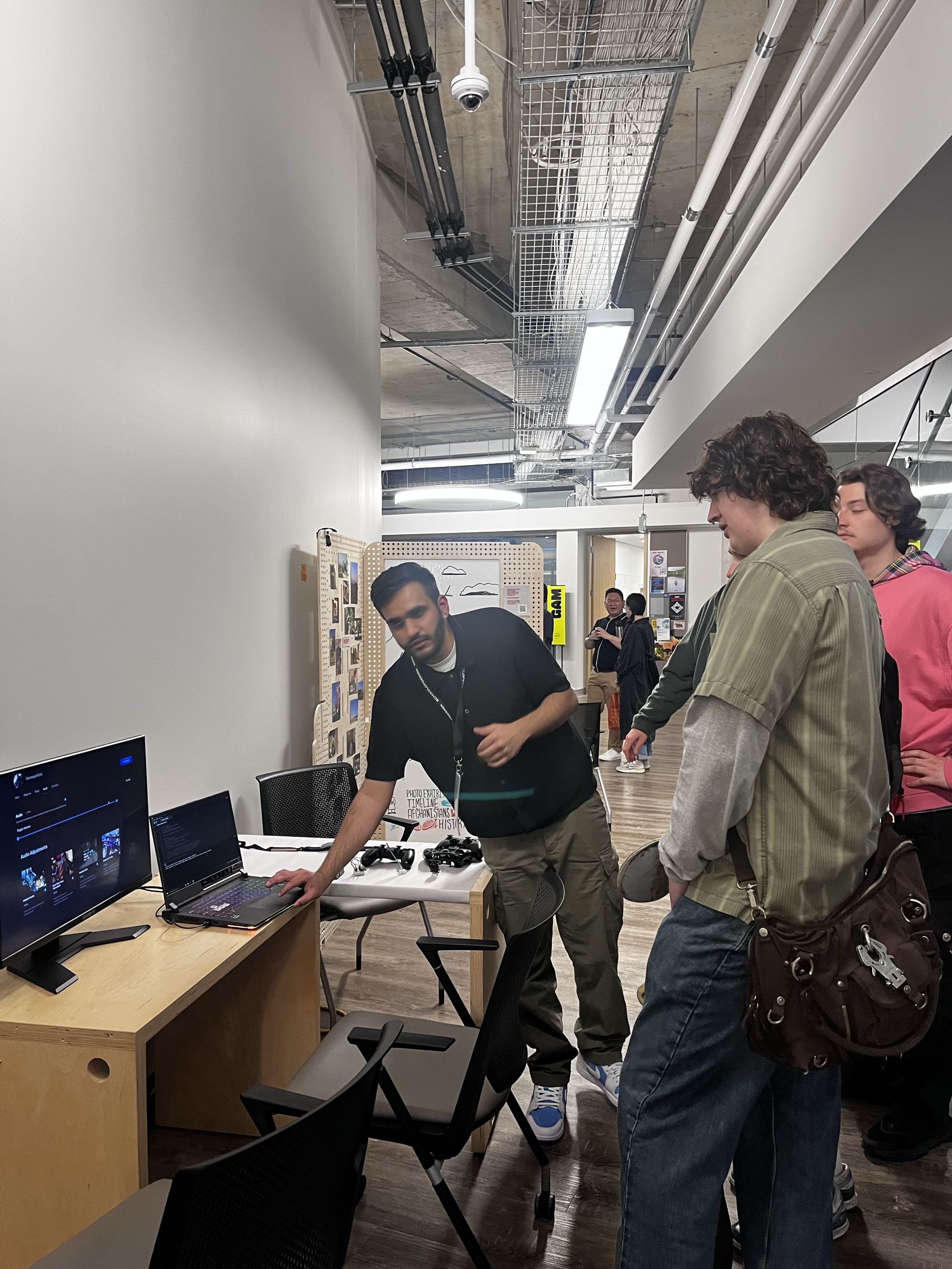 A visitor reviews the BlitzMind companion app while Dhruv demos the adaptive controller
